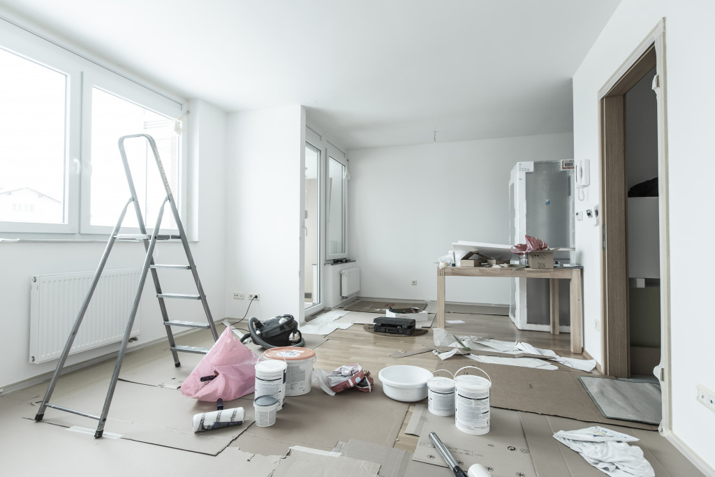 plain white room with renovation materials scattered on the floor